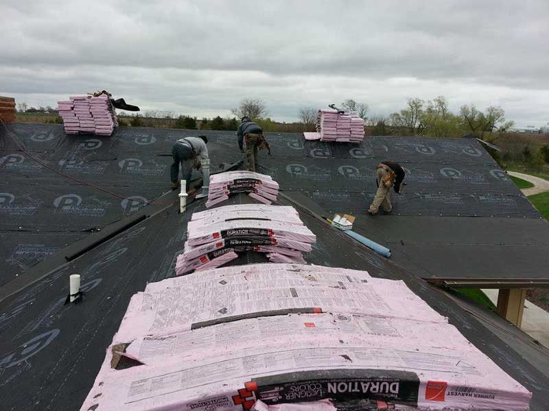 Action Roofing & Construction team members getting a residential roof ready for new shingles to be installed