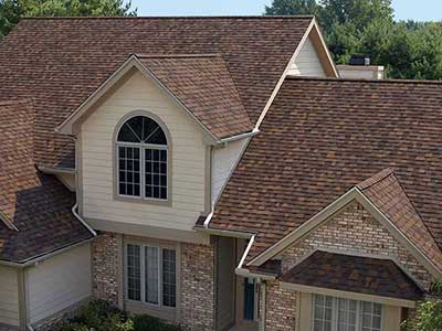 Typical mid-class home with brownish-red Owens Corning shingles on its roof