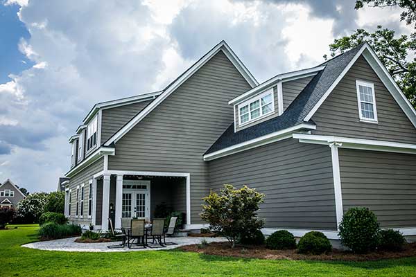 Side view of a residential home with gray vinyl siding